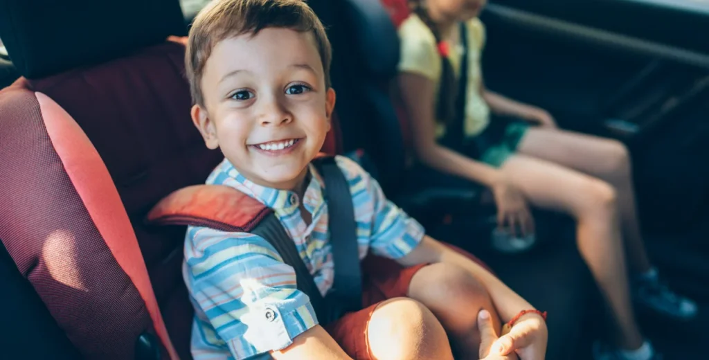 Smiling child in seatbelt enjoying school transport services