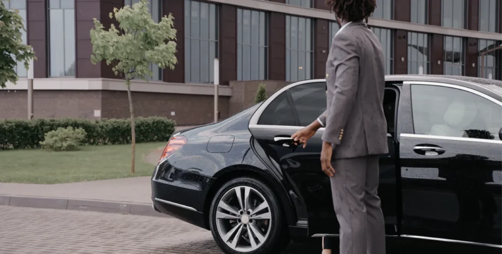 Chauffeur opening door of a luxury wedding cab